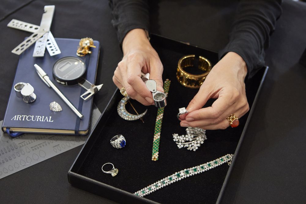 Expert examining fine jewellery during an Artcurial valuation